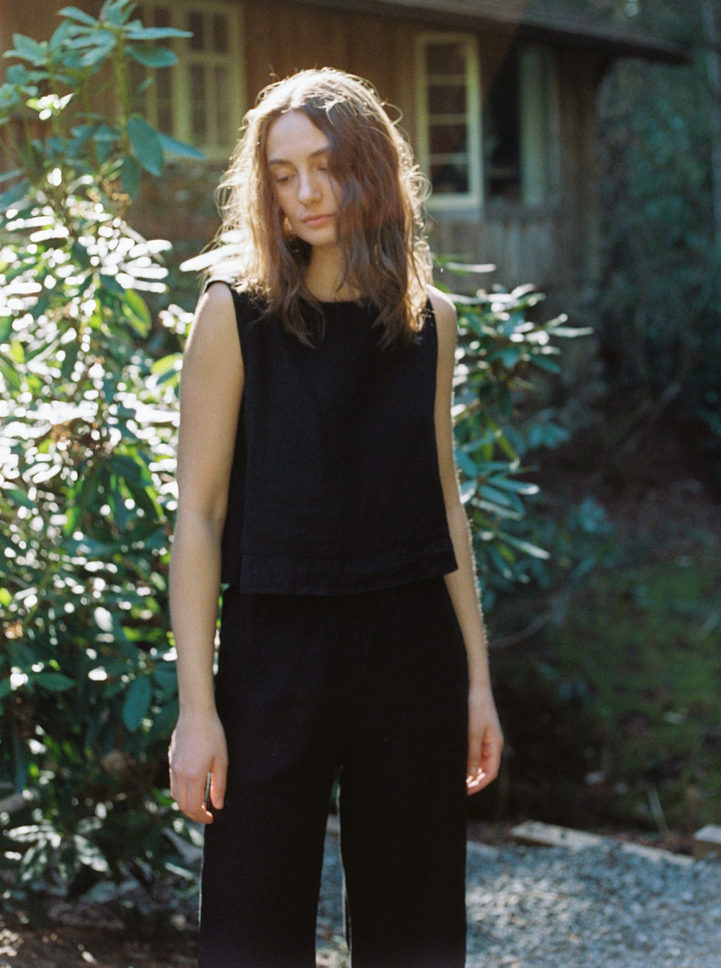 Model wearing the Finley Top in Noir by Gillian Stevens, front view in a garden setting