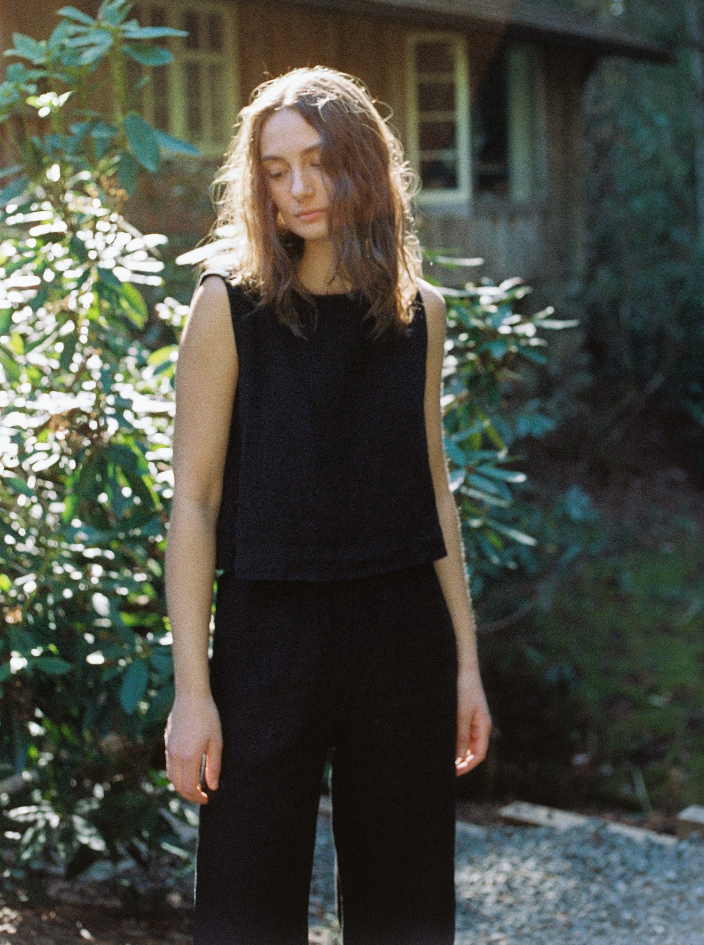 Model wearing the Finley Top in Noir by Gillian Stevens, front view in a garden setting