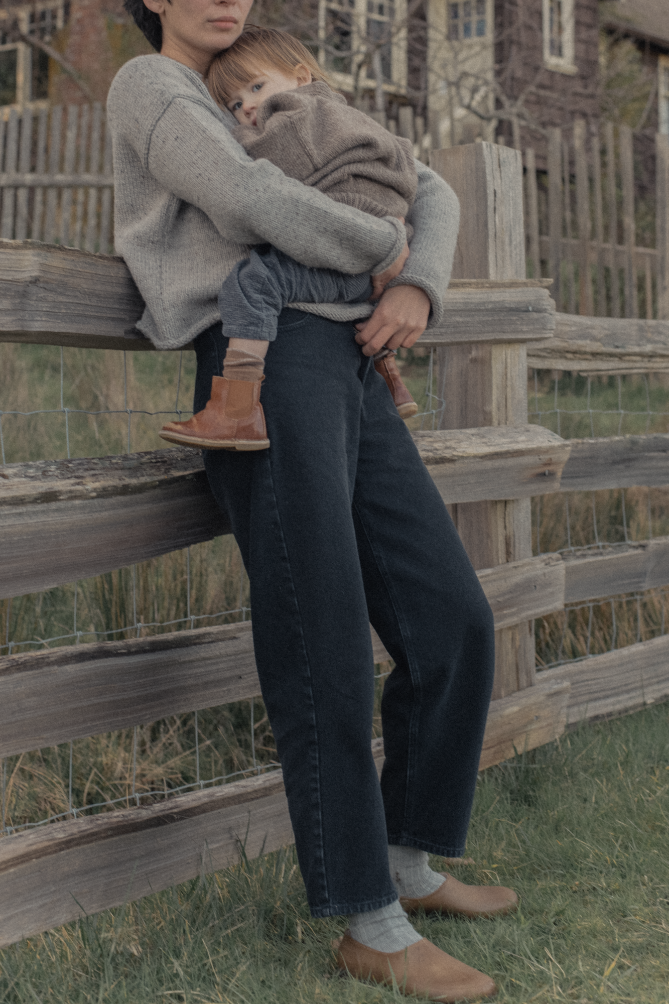 Model wearing the Dara Jean in Noir by Gillian Stevens, full-length outdoor view by a rustic fence
