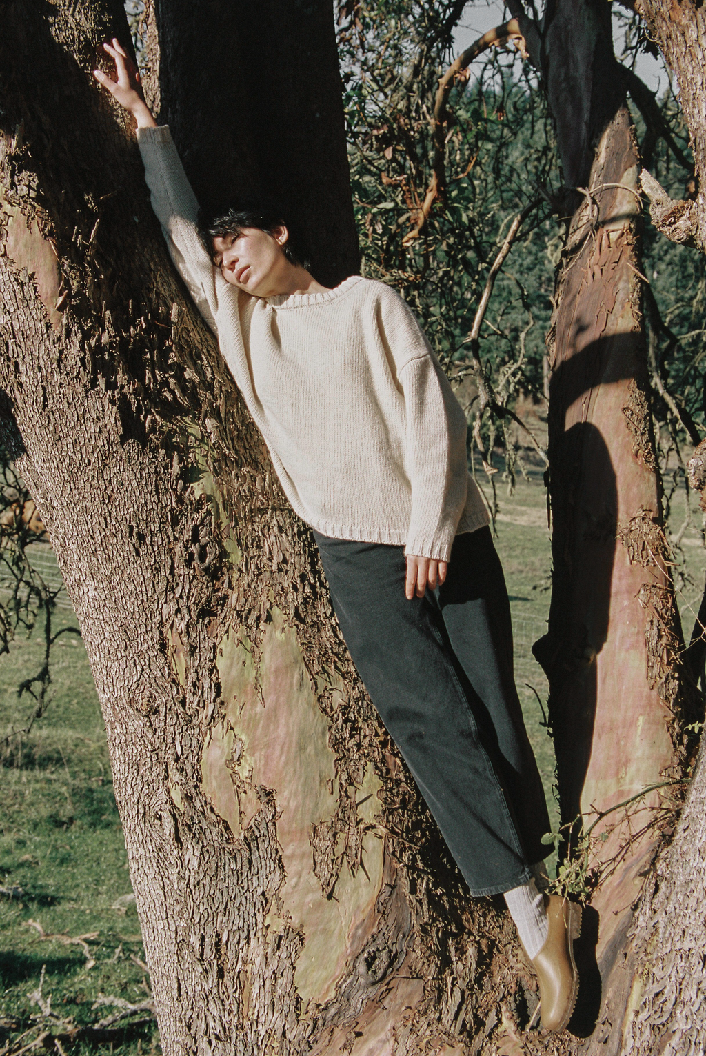 Model wearing the Dara Jean in Noir by Gillian Stevens, leaning against a tree outdoors